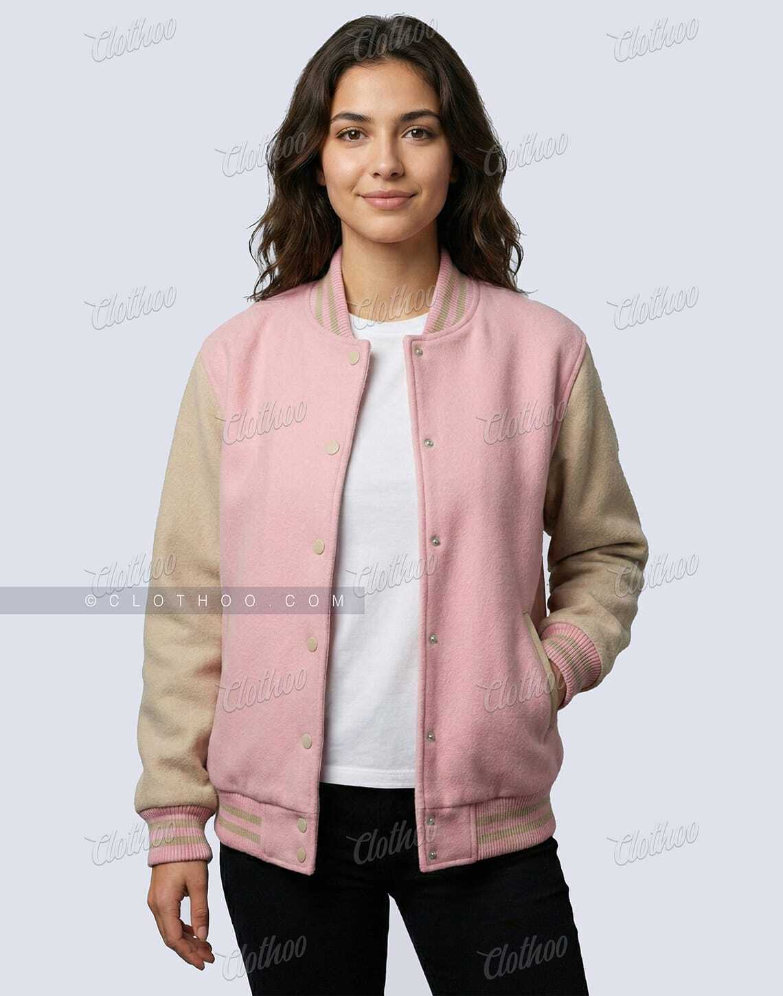 Woman wearing baby pink and beige wool varsity jacket open over a white T-shirt, casual front view